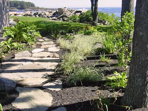 a custom stone path walkway mimics beach landscape features