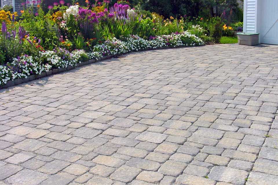 paver driveway lined with perennial gardens