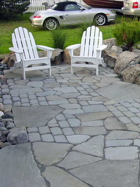 large slabs of stone and smaller stone pavers form patio sitting area