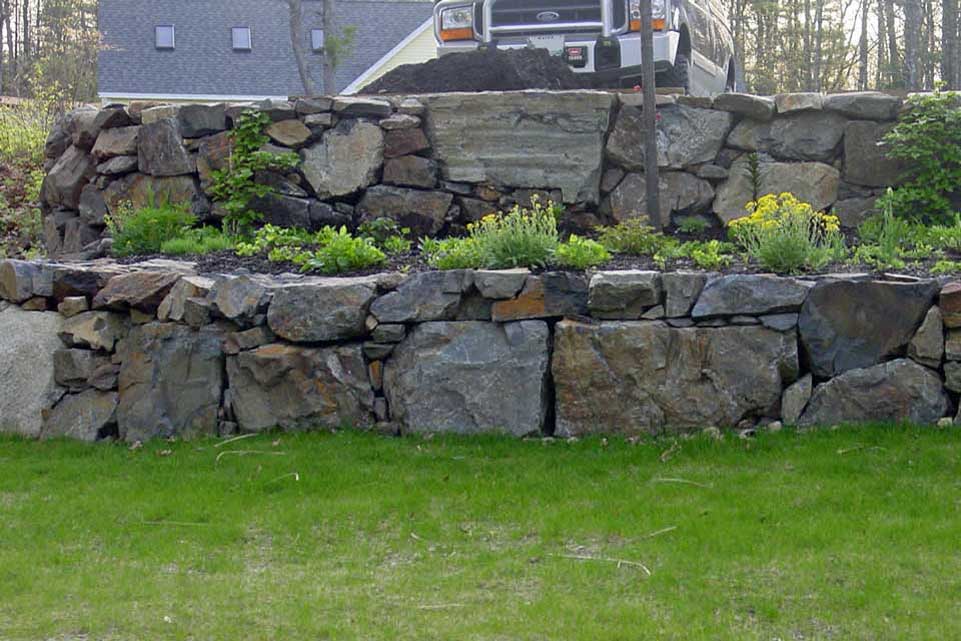 randomly-sized stones create a terraced retaining wall