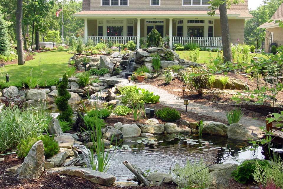 large landscaped pond and plantings enhance the front yard