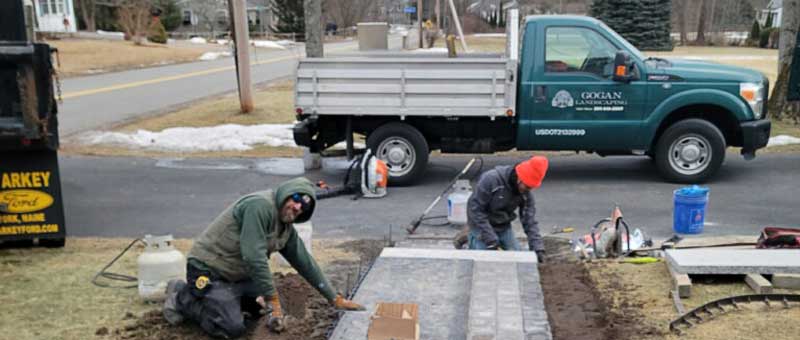 team members work in off-season installing paver walkway